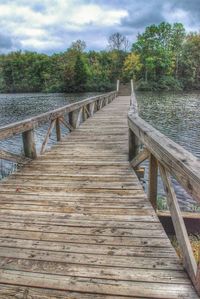 Bridge over river against cloudy sky