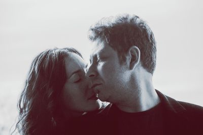 Portrait of couple kissing against white background