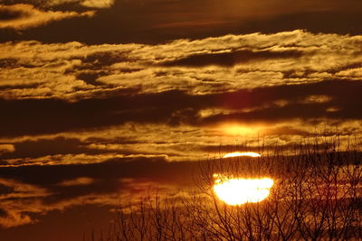 Scenic view of dramatic sky over lake during sunset