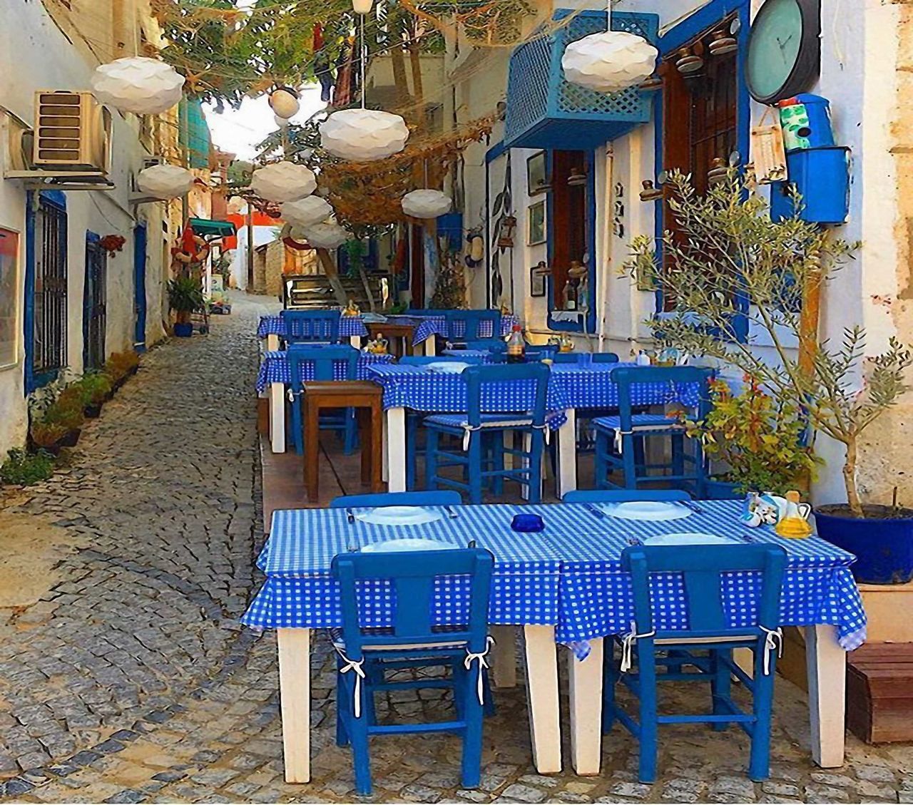 EMPTY CHAIRS AND TABLES AT SIDEWALK CAFE BY BUILDINGS