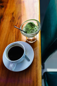 High angle view of coffee and green tea ice cream cup on table