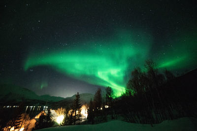 Scenic view of illuminated snowcapped mountains against sky at night