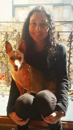 Portrait of smiling young woman with dog