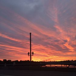 Silhouette street against dramatic sky during sunset