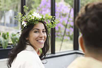 Portrait of smiling woman wearing flower tiara at patio
