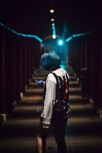 Rear view of woman walking on illuminated stage