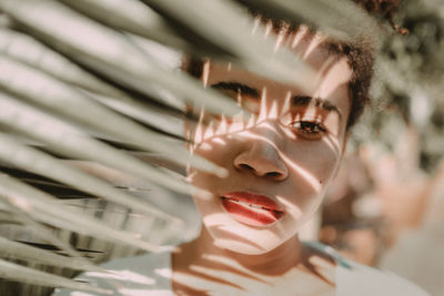 Close-up portrait of woman by leaves