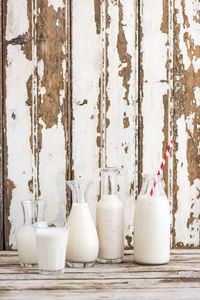 Milk in bottles and glass on table