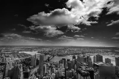 Aerial view of cityscape against cloudy sky