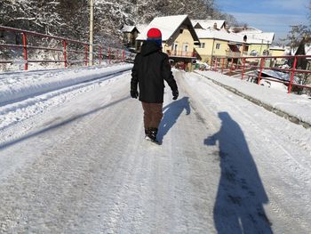 Rear view of man on snow covered city