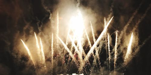 Low angle view of firework display at night