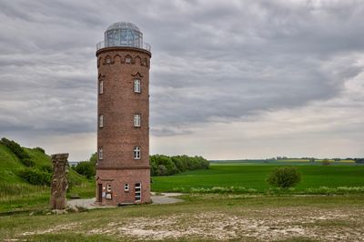 Castle on field against cloudy sky