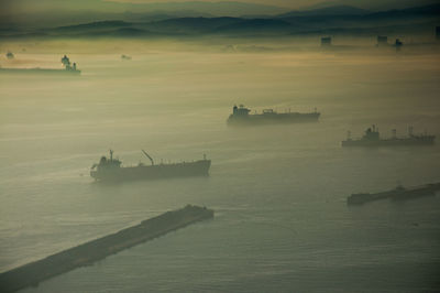 High angle view of ships sailing in sea during foggy weather