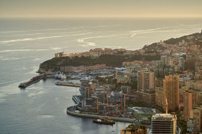 High angle view of city by sea against sky