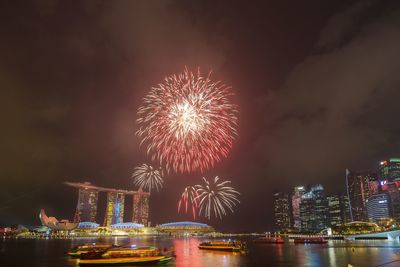 Firework display over river at night