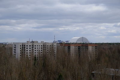 Buildings on field against sky