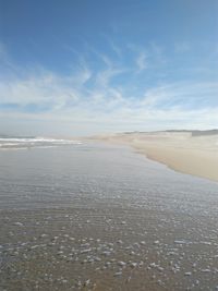 View of calm beach against blue sky