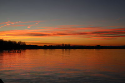 Scenic view of lake against romantic sky at sunset