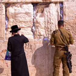 Rear view of man standing against wall