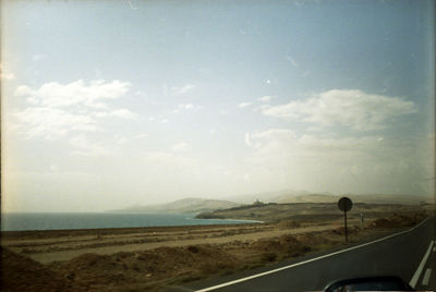 Road by landscape against sky