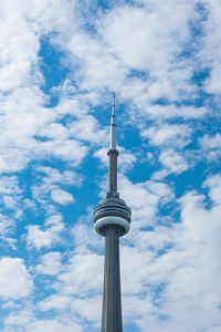 Low angle view of communications tower against cloudy sky