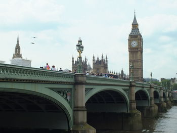 View of tower bridge over river against sky in city