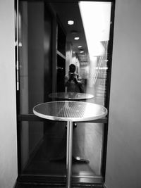 Reflection of woman sitting on glass window