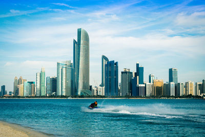 Scenic view of sea by buildings against sky