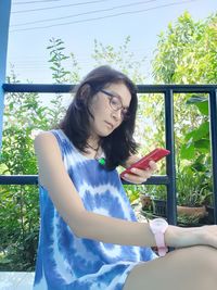 Young woman sitting on window