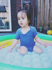 Cute girl sitting in swimming pool