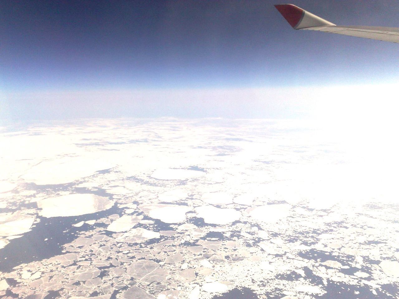 airplane, transportation, flying, aircraft wing, sky, air vehicle, landscape, scenics, mode of transport, aerial view, beauty in nature, nature, tranquil scene, tranquility, part of, cropped, snow, mountain, blue, mid-air