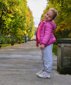 Portrait of young woman walking on road