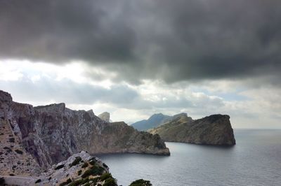 Scenic view of sea and mountains against sky