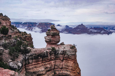 View of rock formation against cloudy sky