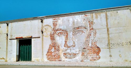 Low angle view of weathered wall against building