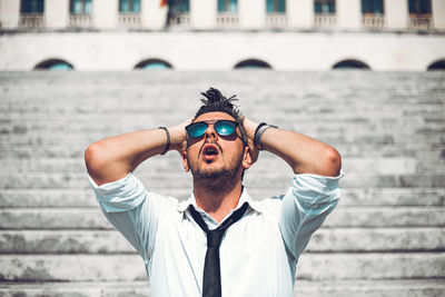 Portrait of young man wearing sunglasses standing outdoors