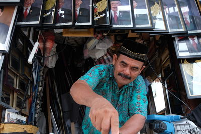 Portrait of a smiling young man. a frame expert is framing a photo