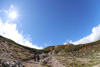 Woman walking on mountain against sky