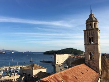 Bell tower by sea against sky