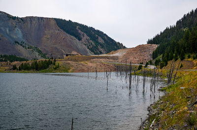 Scenic view of lake by mountain against sky