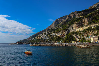 View of the town of amalfi from the jetty with, the sea, boats and colorful house