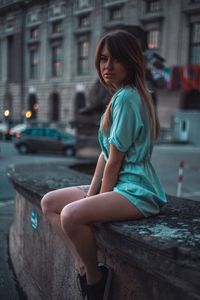 Side view of woman sitting in city