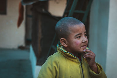 Thoughtful boy looking away standing outdoors