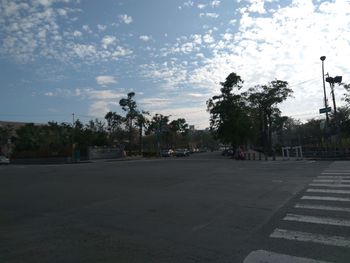 Road by trees against sky