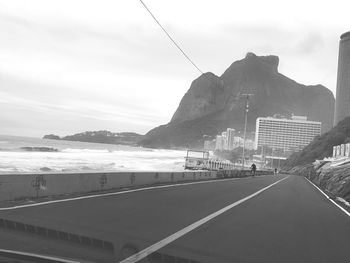 Road by mountain against sky