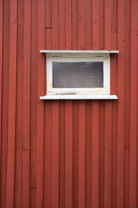 Full frame shot of window on red wooden wall