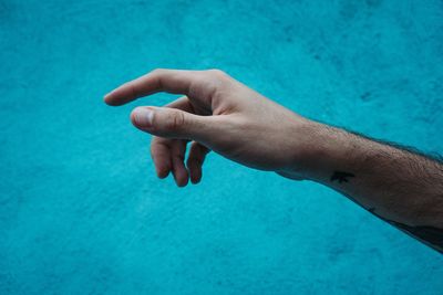 Cropped hand gesturing against wall