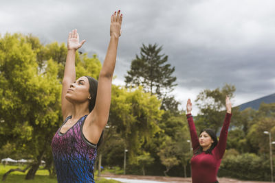 Two women making yoga on the park