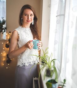 Portrait of woman drinking coffee at home