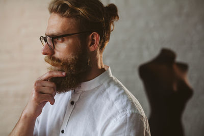 Fashion designer looking away while standing in workshop